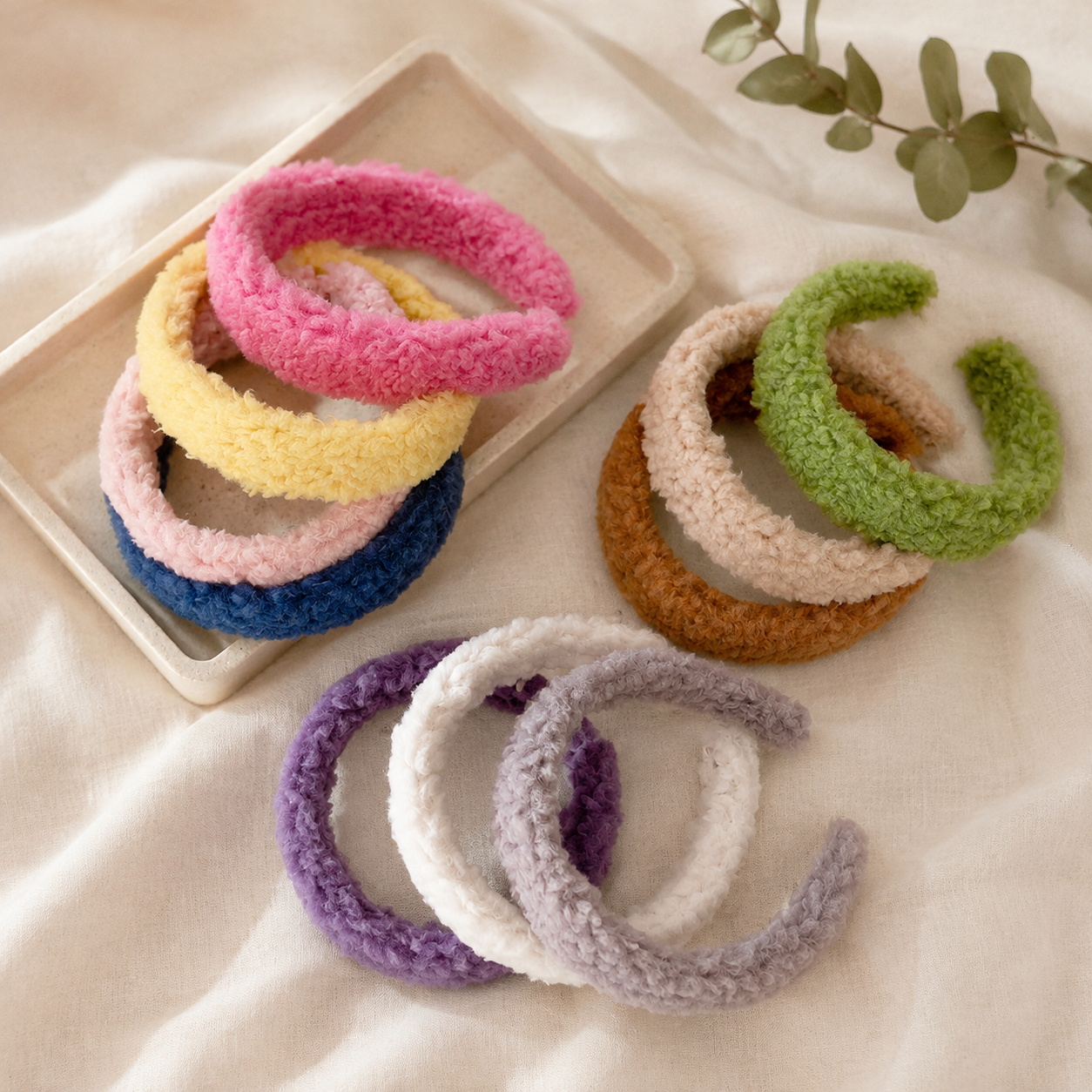 Plush fuzzy headbands arranged on a beige tray